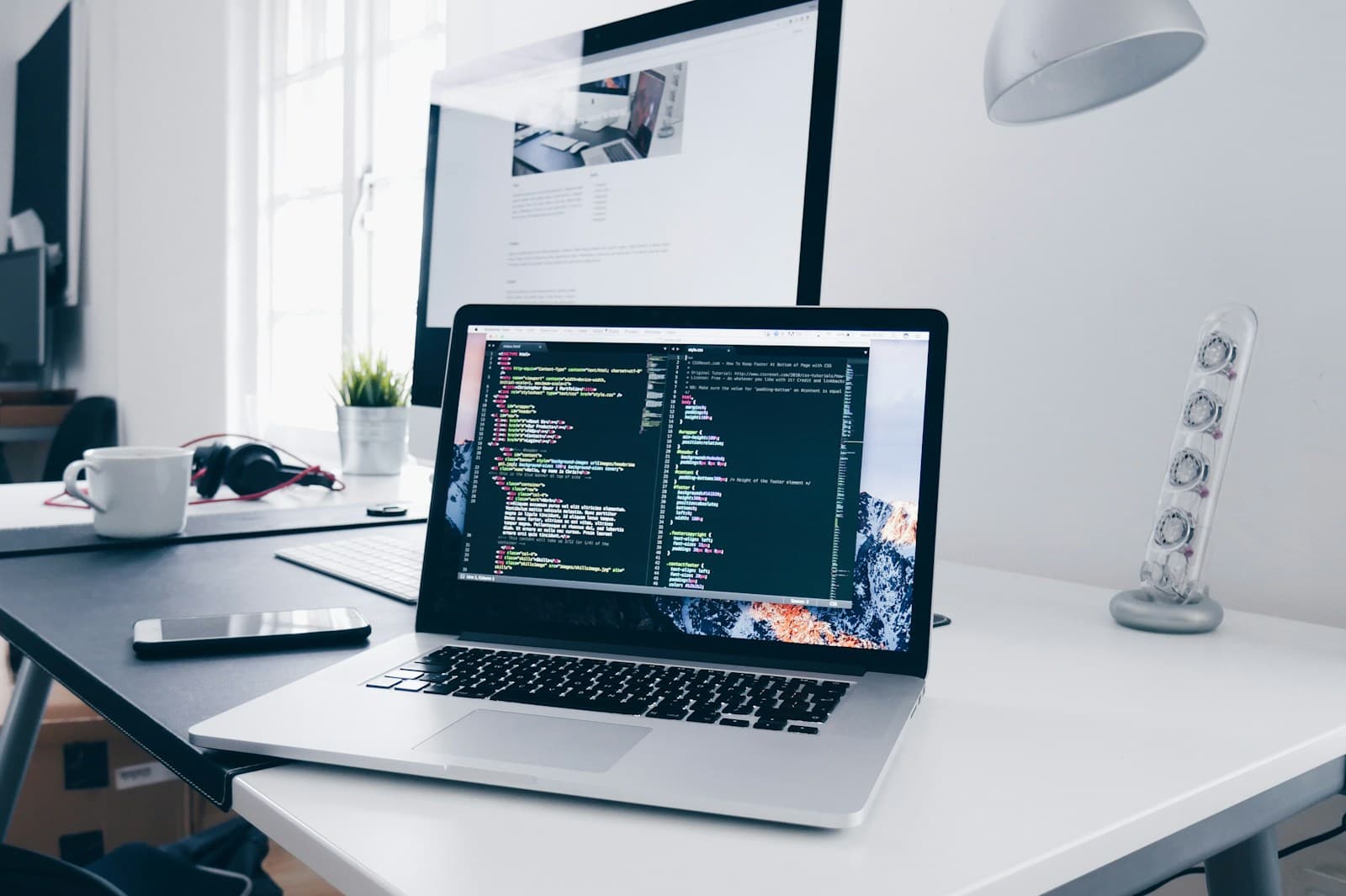 Laptop showing code on a bright desk